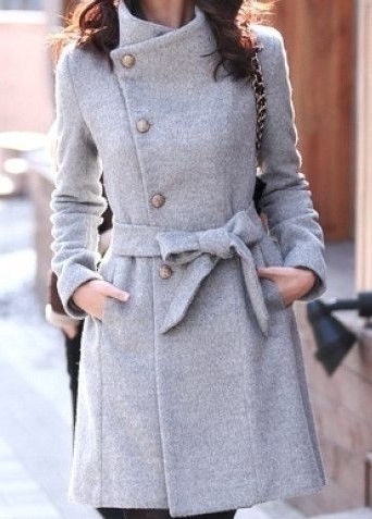 Девушка в стильном, сером пальто с бантиком спереди